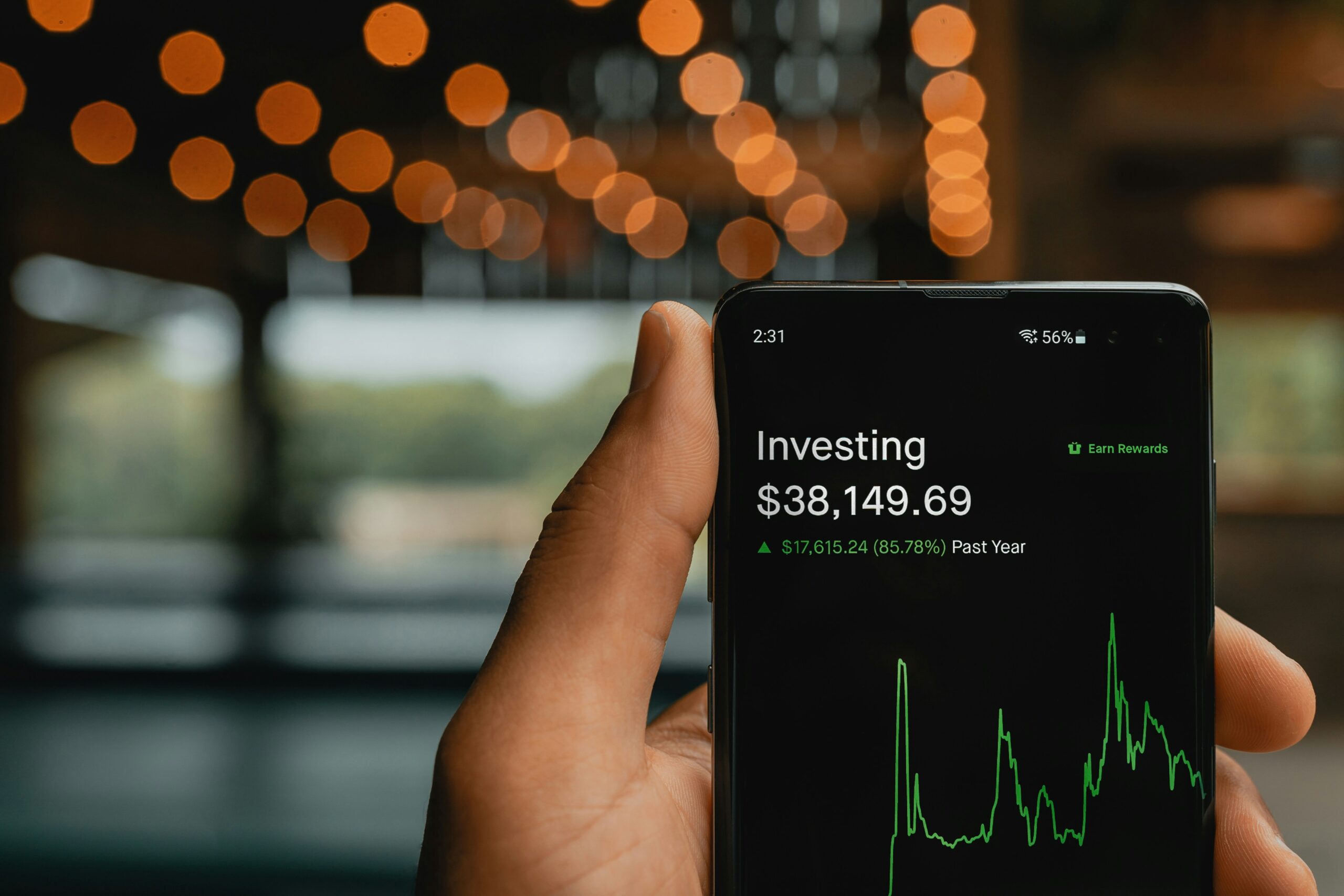 how to start investing with $100 or less - person using smartphone investing app with small dollar amounts - Photo by PiggyBa